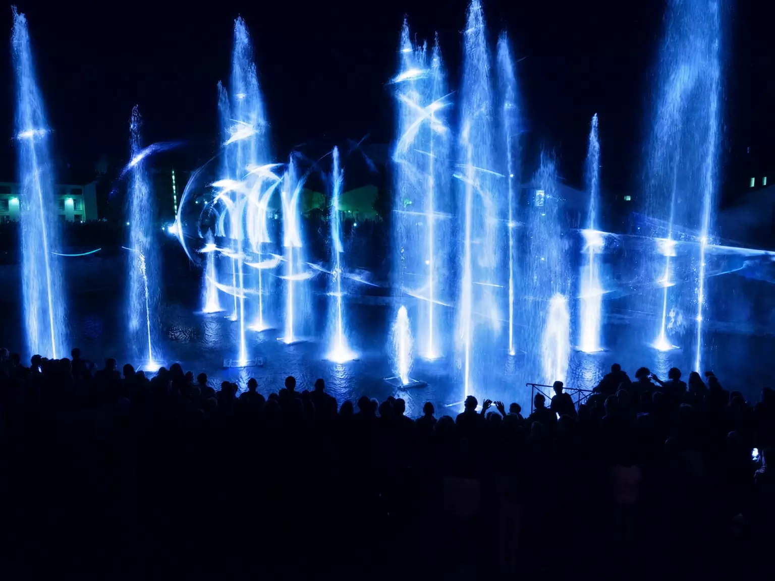 Spectacle Waterworks à Niort avec fontaines lumineuses bleues, effets laser et public rassemblé de nuit au bord de l’eau.