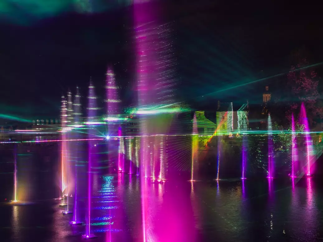Spectacle nocturne Waterworks à Angers avec jets d’eau lumineux, lasers colorés et scénographie aquatique sur la rivière.