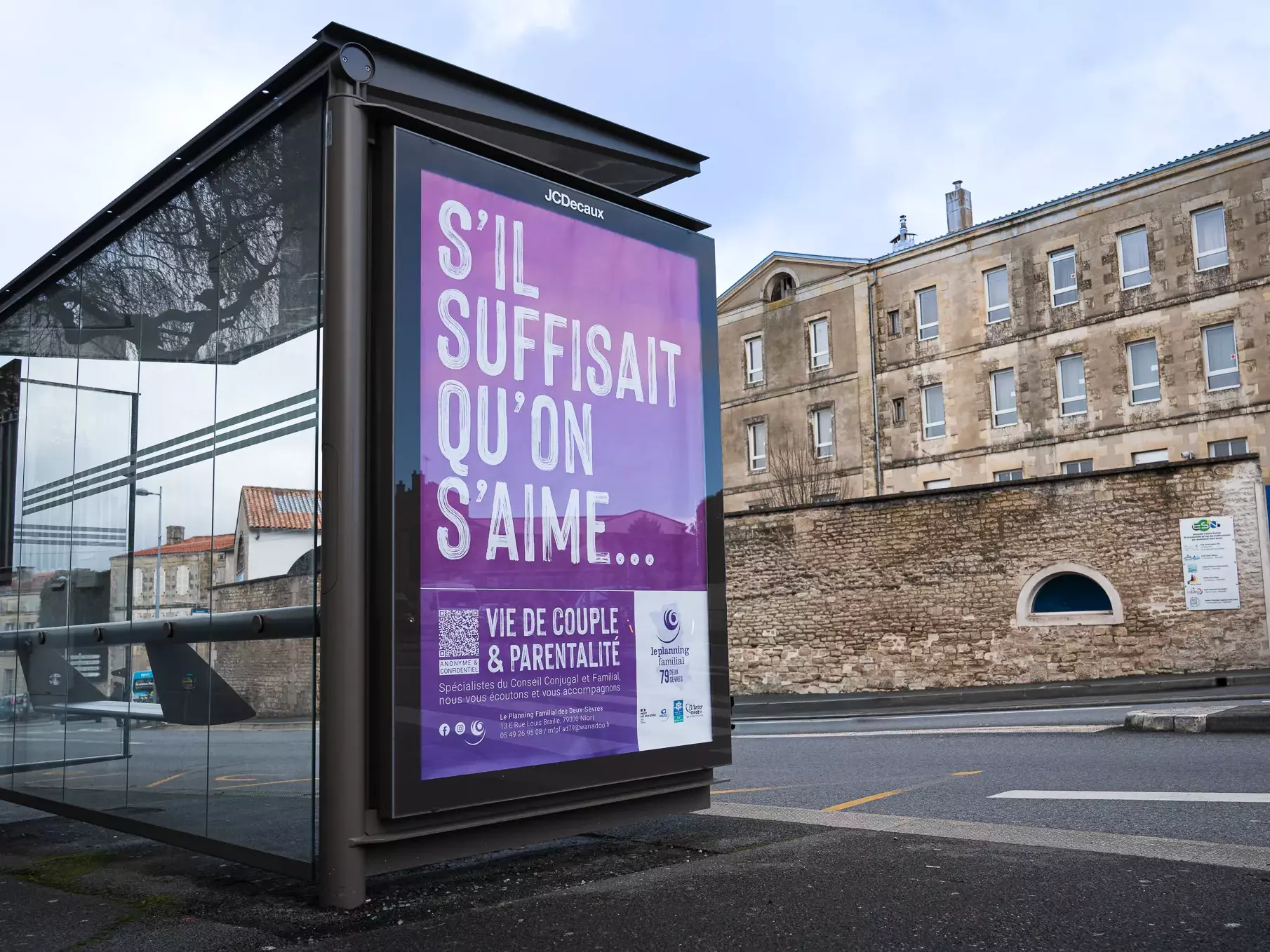 Panneau d'affichage d'abribus présentant une affiche du Planning Familial avec le texte S'IL SUFFISAIT QU'ON S'AIME...