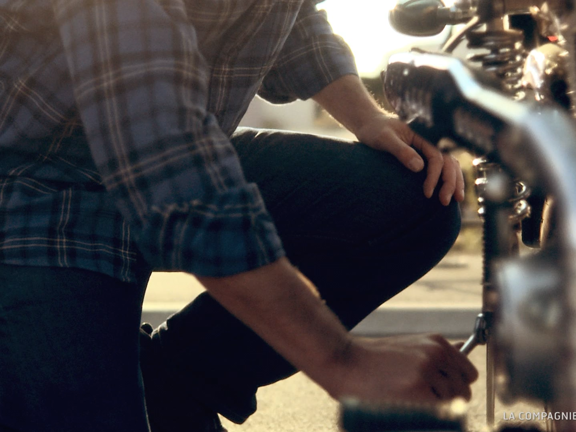 Image issue d’une production audiovisuelle pour le Crédit Agricole, montrant une personne accroupie près d’une moto avec lumière naturelle et rendu cinématographique.